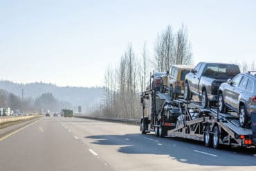 A car trailer used by car shipping companies travels down a highway.