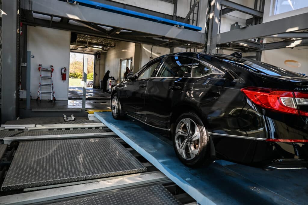 A black Honda Accord sitting inside a Carvana vending machine.