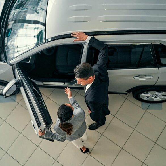 Customer with a grayscale vehicle on a showroom floor