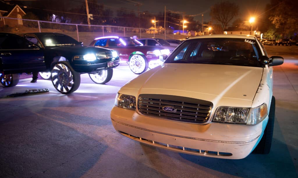 A group of modified Crown Victoria cars sit in a parking lot