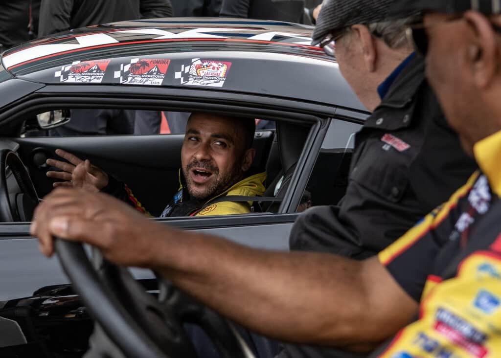 an nhra drag race driver talks to crew members