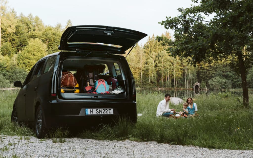 a sono motors sion ev parked in a natural area with the trunk open