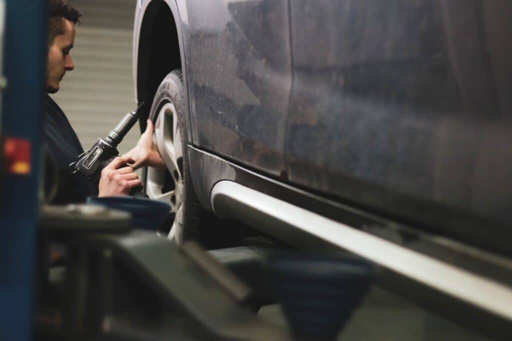 a mechanic works on the wheel of a car